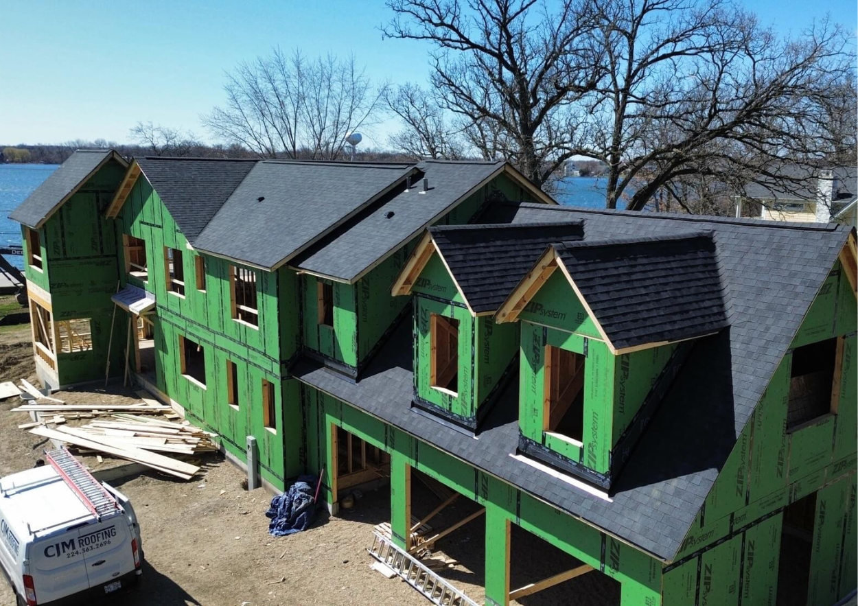 Upscale Northern Illinois home with a newly installed asphalt shingle roof at dusk